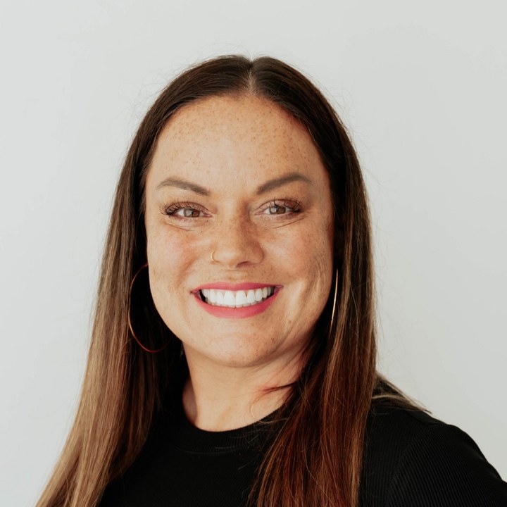 Tiffany McGhee, Aiken local and Realtor, smiling in a black top against a light studio backdrop