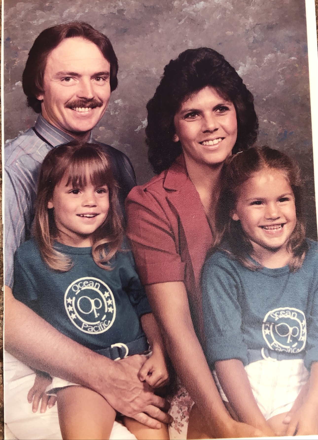 A vintage family portrait of a young Tiffany McGhee with her dad, her mama Sue, and her sister Stephanie