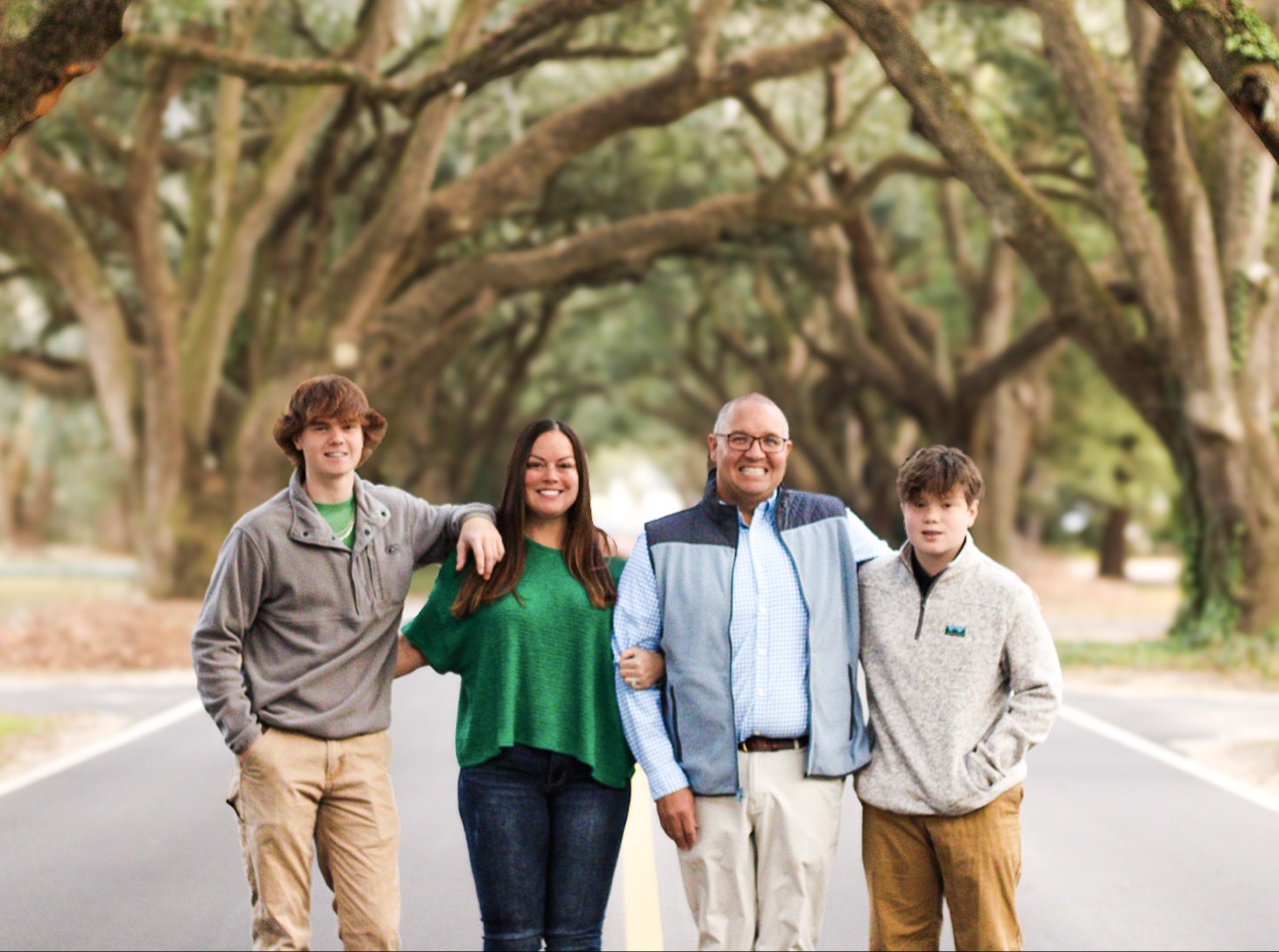 Tiffany McGhee with her husband Michael and her sons Davis and Brooks, standing together beneath a canopy of live oaks in Aiken