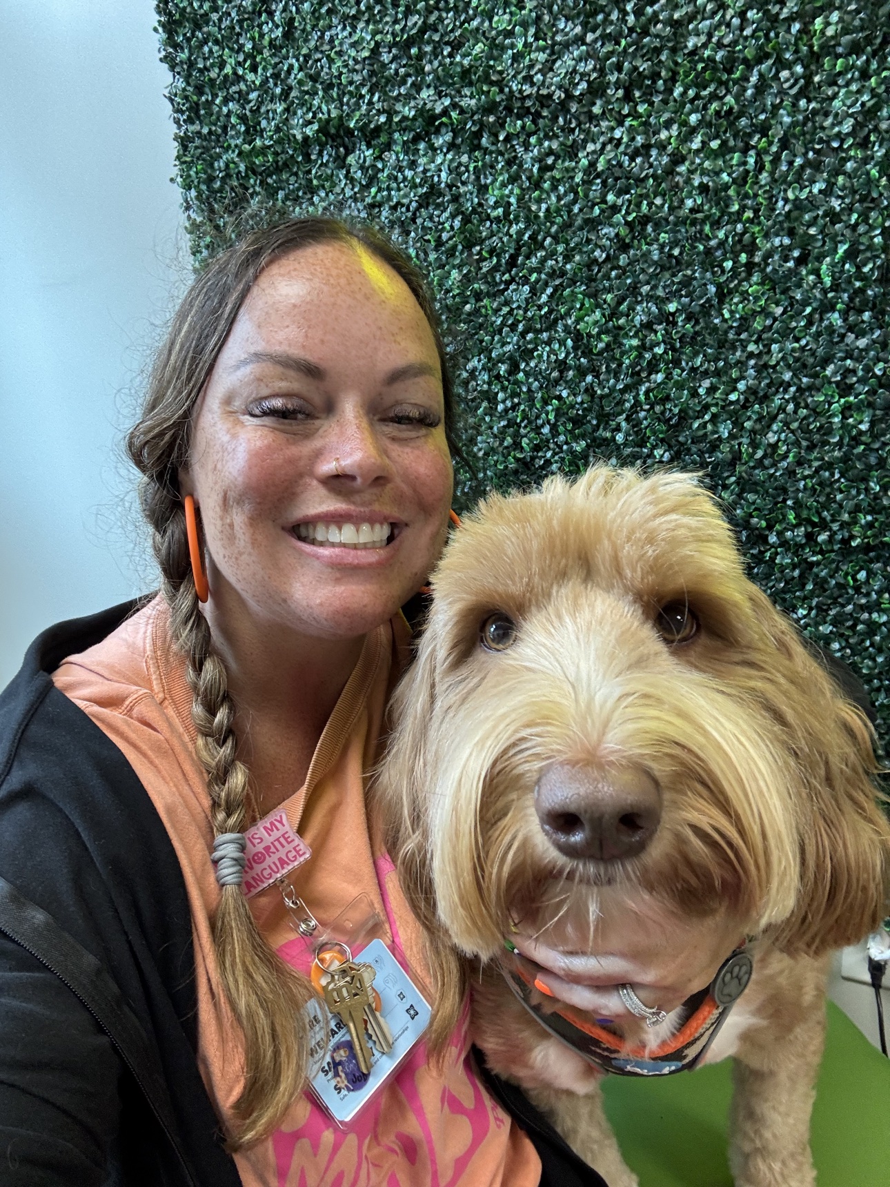 Tiffany McGhee smiling cheek-to-cheek with her fluffy golden dog